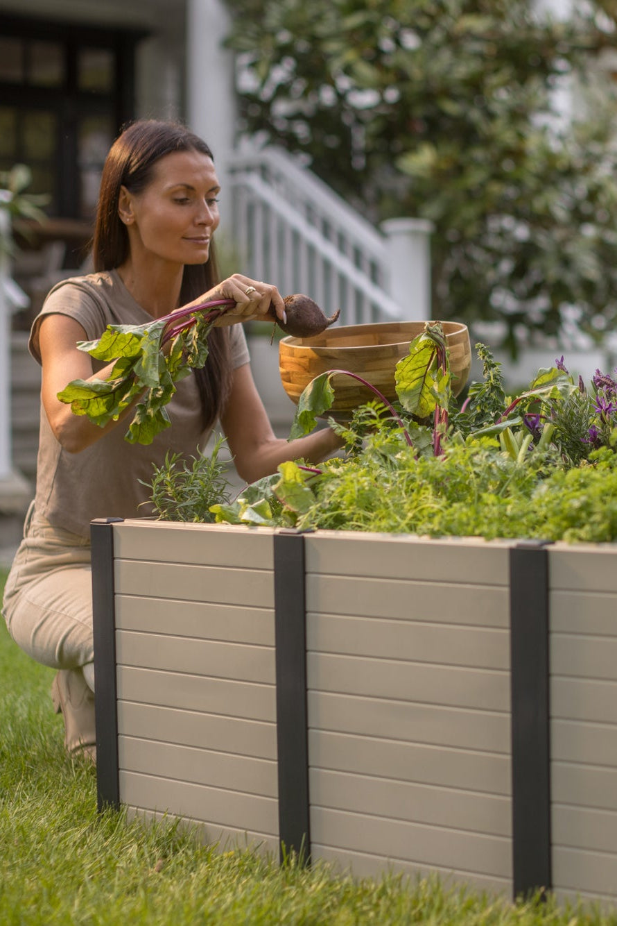 Woman tending to a garden in a raised bed outdoors
